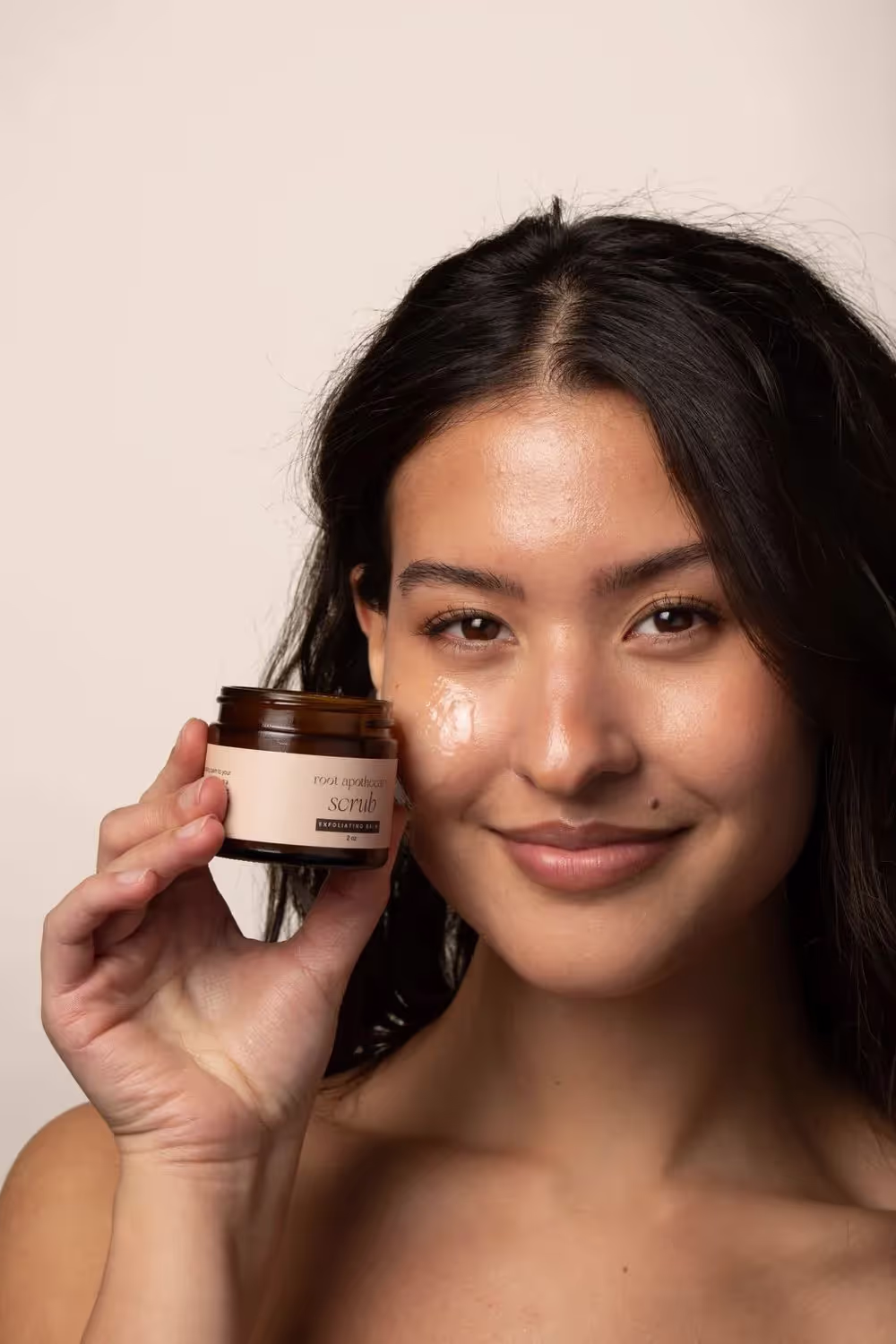 a woman holding facial scrub